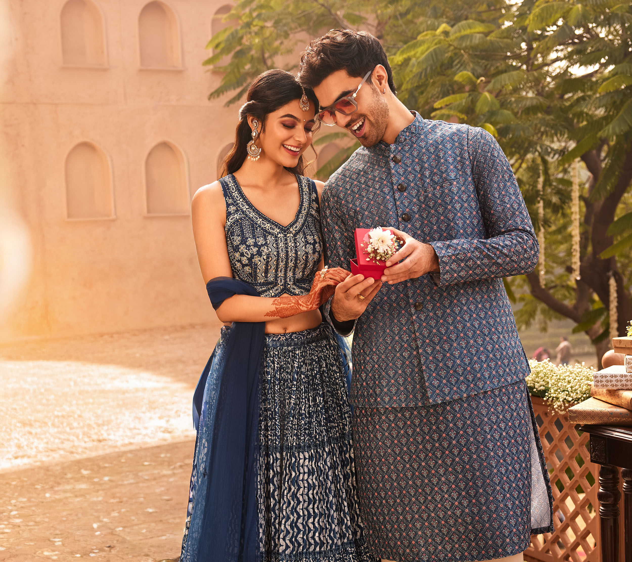 Indian pre-wedding couple in ethnic attire at royal palace setting.